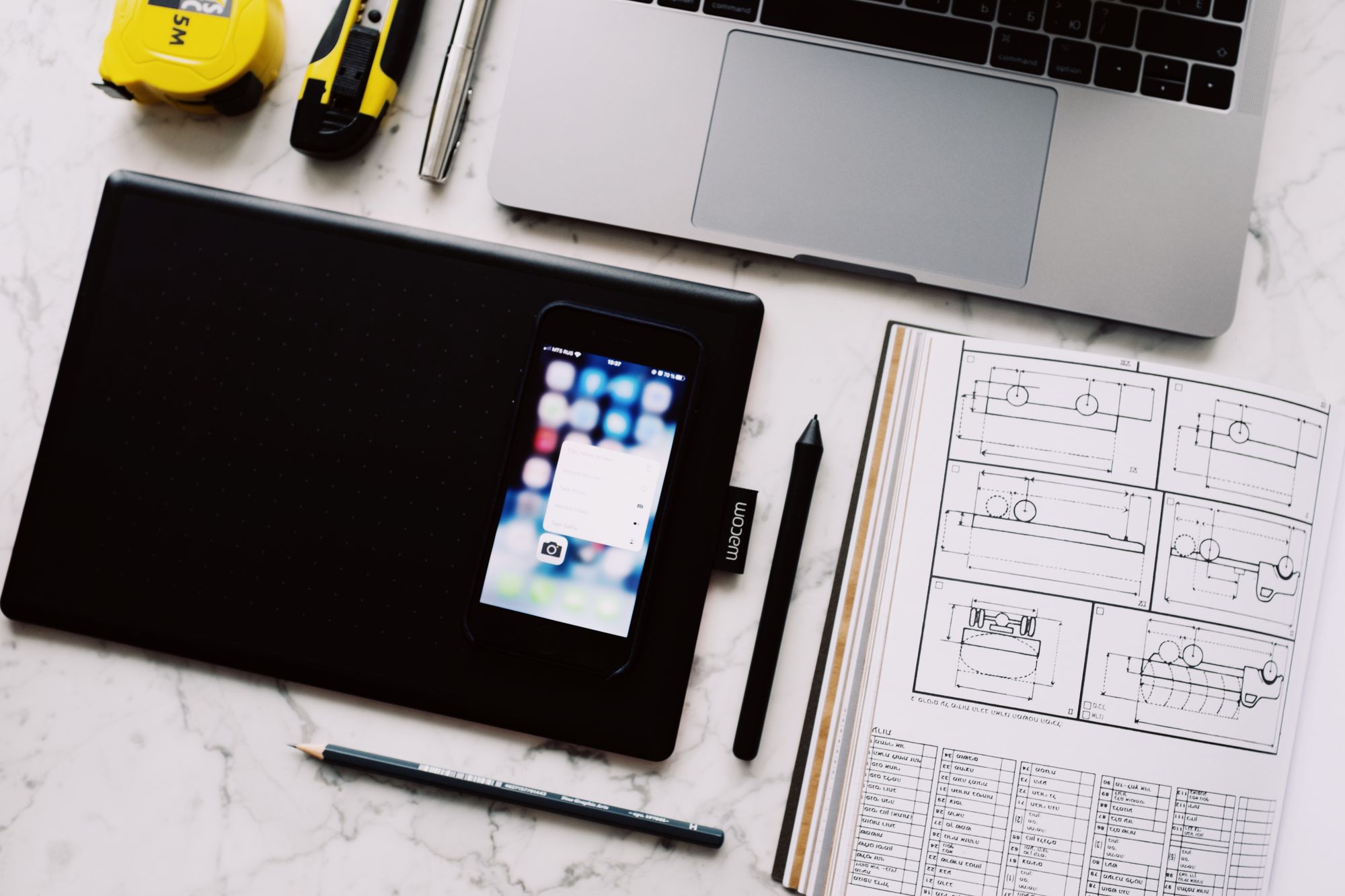 Laptop, tablet, and smartphone connected in a modern workplace.